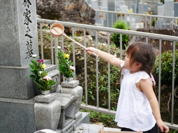 墓参りでお水をかける女の子