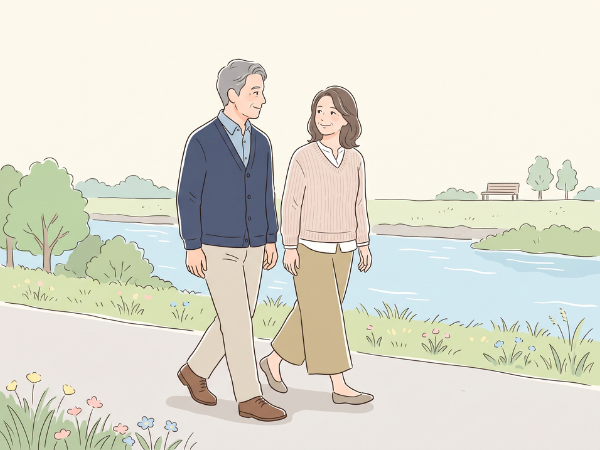 川沿いの歩道を50代の男女が並んで歩いている