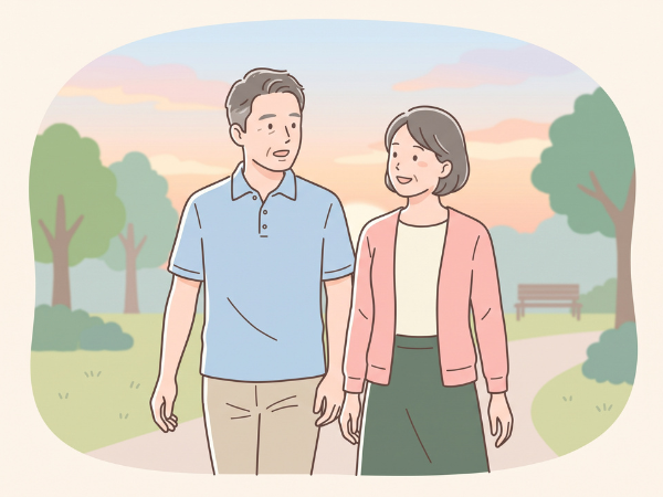 夕暮れの公園を二人仲良く並んで歩く50代カップル